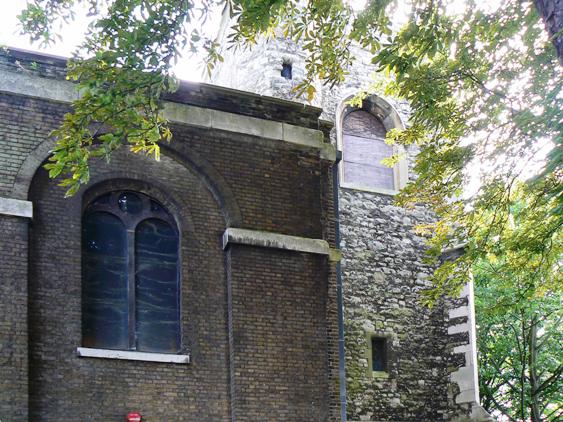 Part of church building and tower, windows boarded up