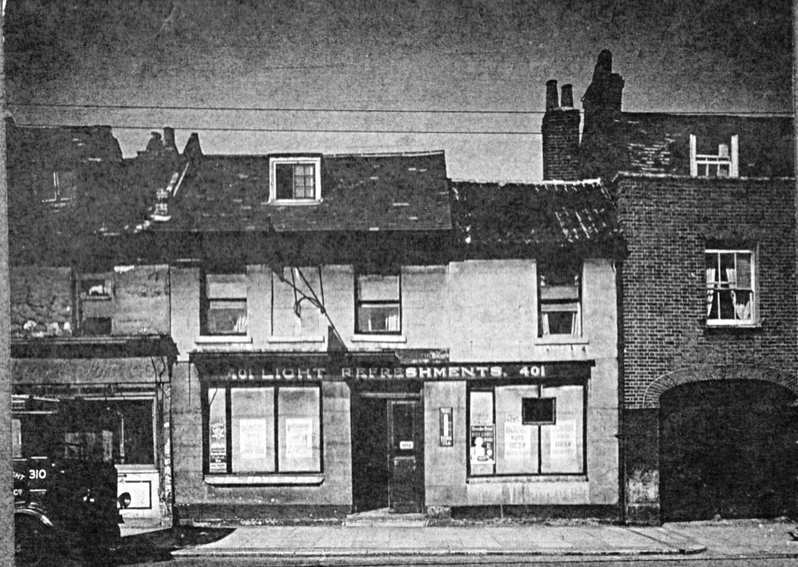 view showing a 2 storey brick built property with sign '401 Light Refreshments 401' and a little of numbers 400 and 402