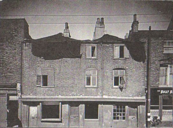 three 3 storey brick built terraced properties with taller buildings on both sides