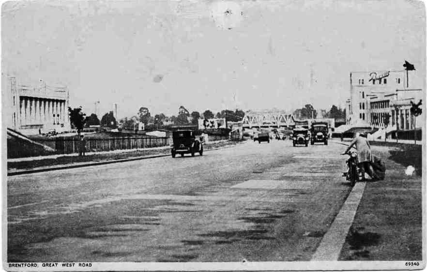 Road with motor traffic, factories to either side