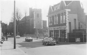 3 storey detached building with church in background