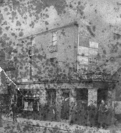 Brick built public house with a group of 10 or so men outside